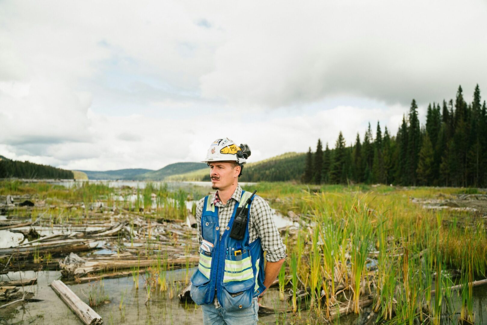 A man standing in the water near some trees.